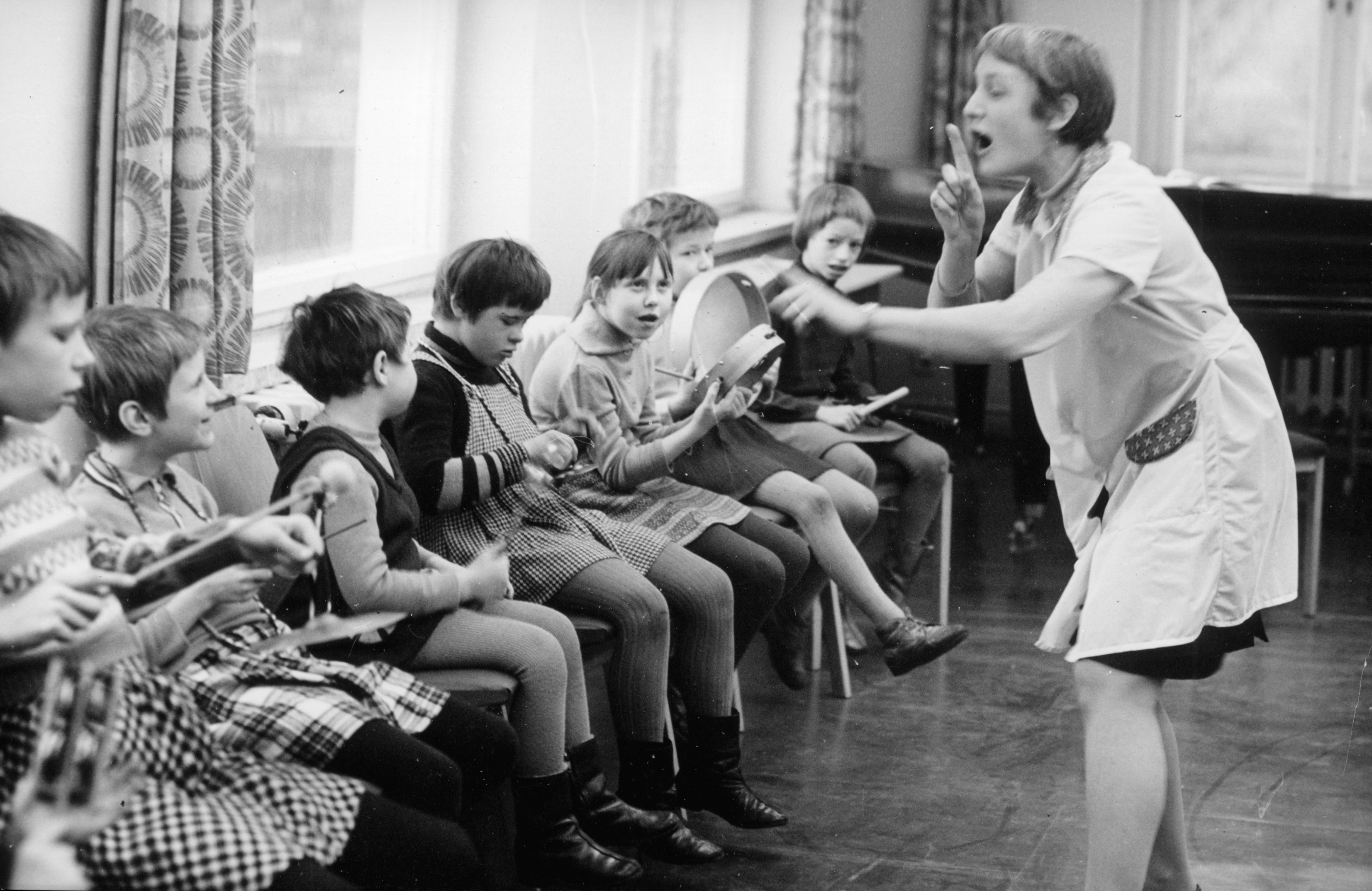 Eine Frau gibt Kindern Musikunterricht